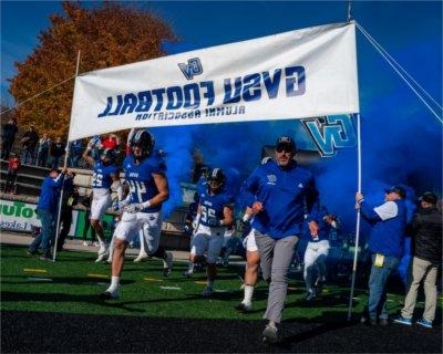 The Grand Valley football team and head coach Scott Wooster run onto the field at Lubbers Stadium.